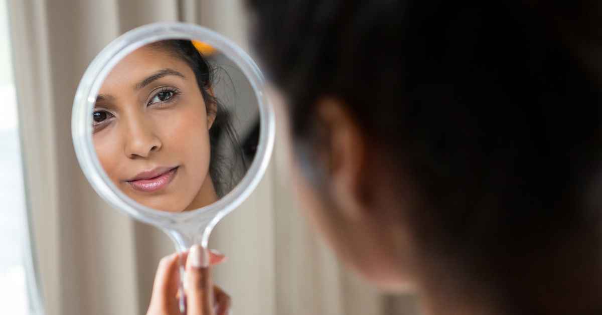 Image of Women Looking in a Mirror - Dr. Bragg shares first step on how to believe in yourself